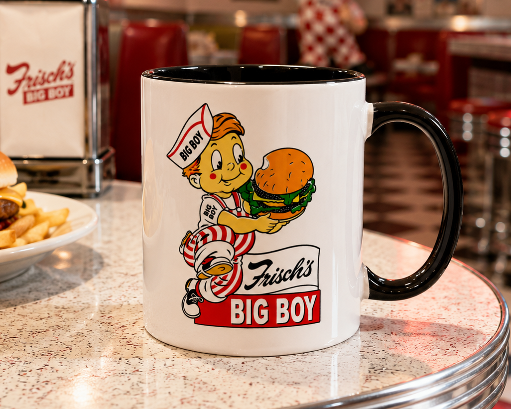 Classic Frisch’s Big Boy logo coffee mug featuring the iconic Big Boy mascot holding a hamburger on a white ceramic mug with black handle and interior.