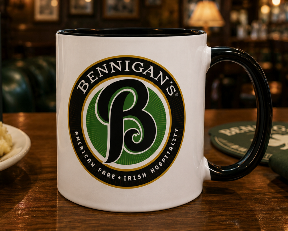 Vintage Bennigan's logo coffee mug featuring the classic Irish Hospitality emblem on a premium white ceramic mug with a black interior and handle, perfect for restaurant nostalgia fans and pub memorabilia collectors.