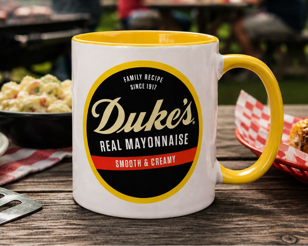 Vintage Duke's Real Mayonnaise logo coffee mug featuring the classic Family Recipe Since 1917 Smooth & Creamy design on a premium white ceramic mug with a yellow handle and interior.